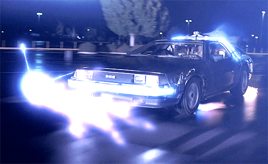 A DeLorean surrounded by blue-white sparks.